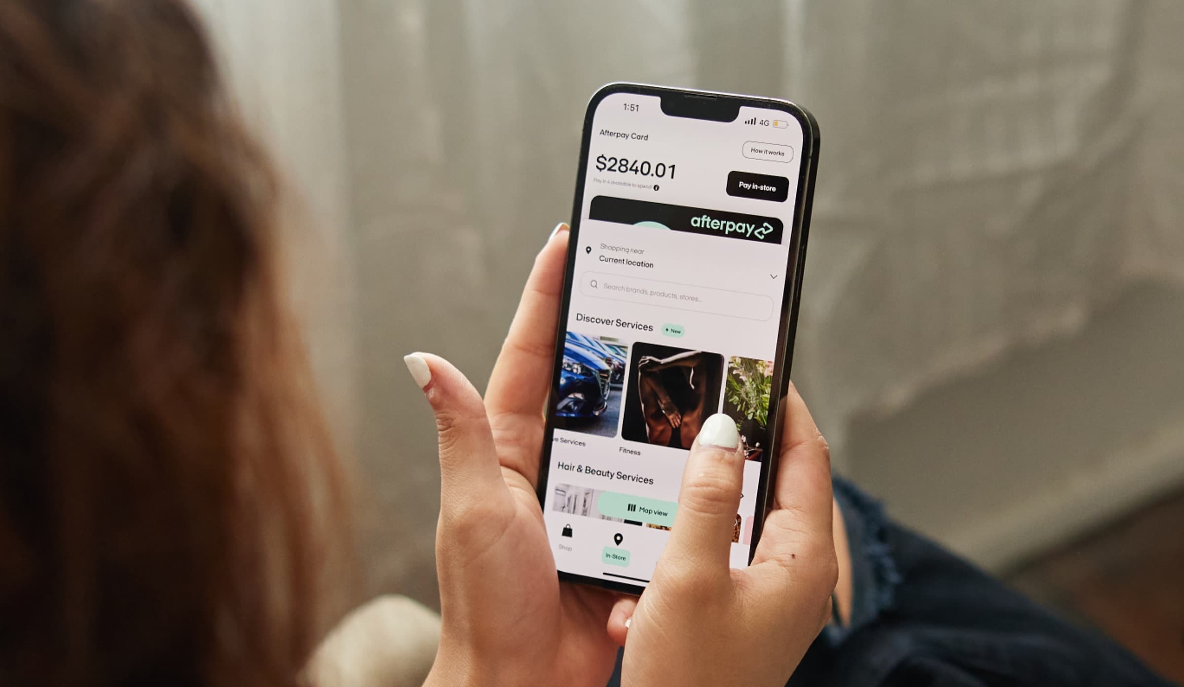 Shopper holding a phone showing the Afterpay app