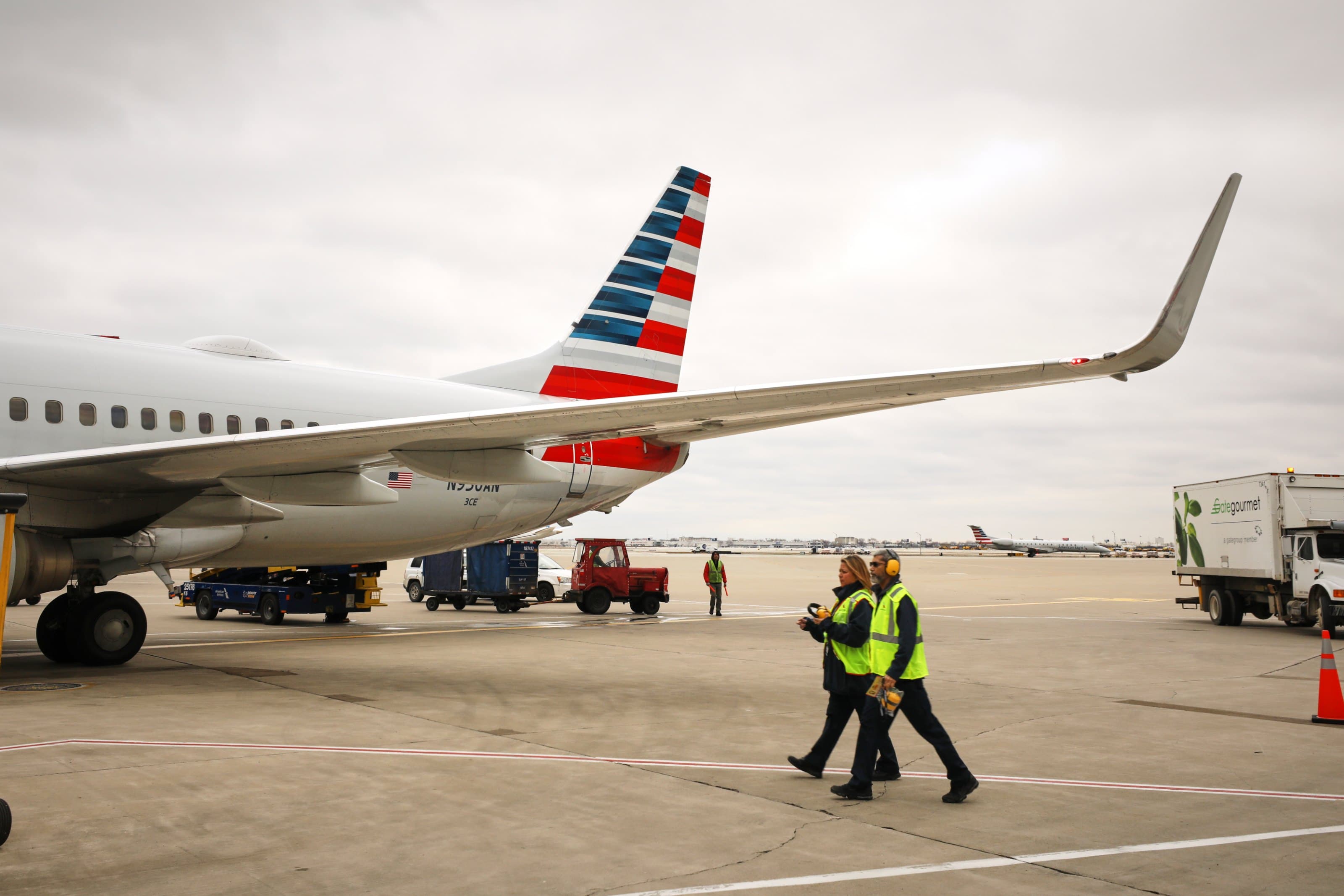 American Airlines ground crew walking beside a Boeing 737 on the tarmac