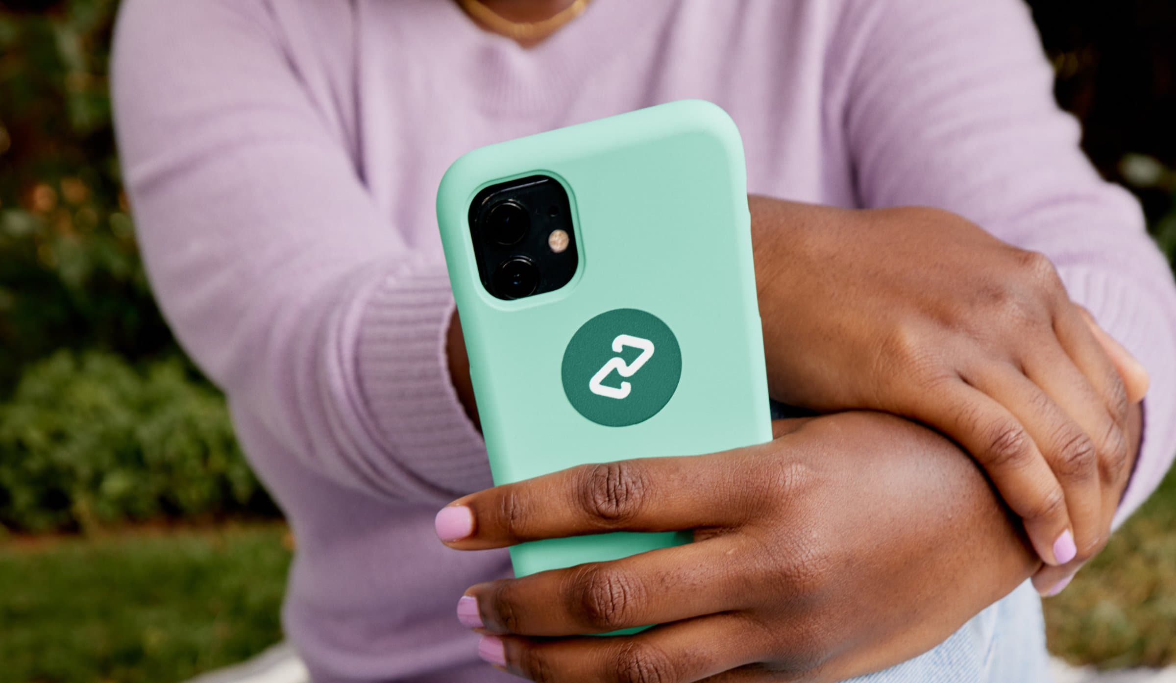 Hand holding a phone in a mint case with the Clearpay logo mark