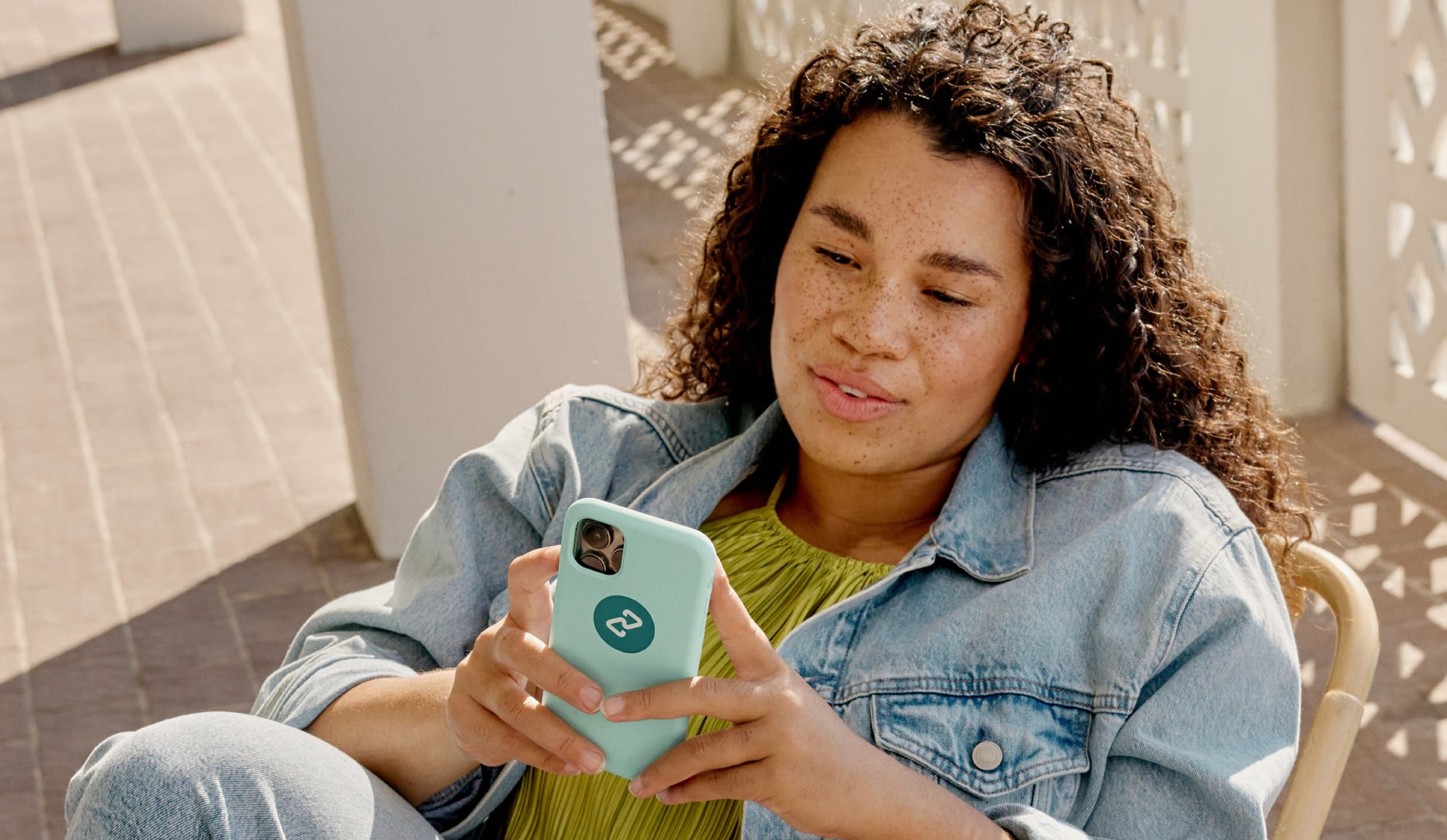 Shopper holding a phone in a mint case with the Clearpay logo mark