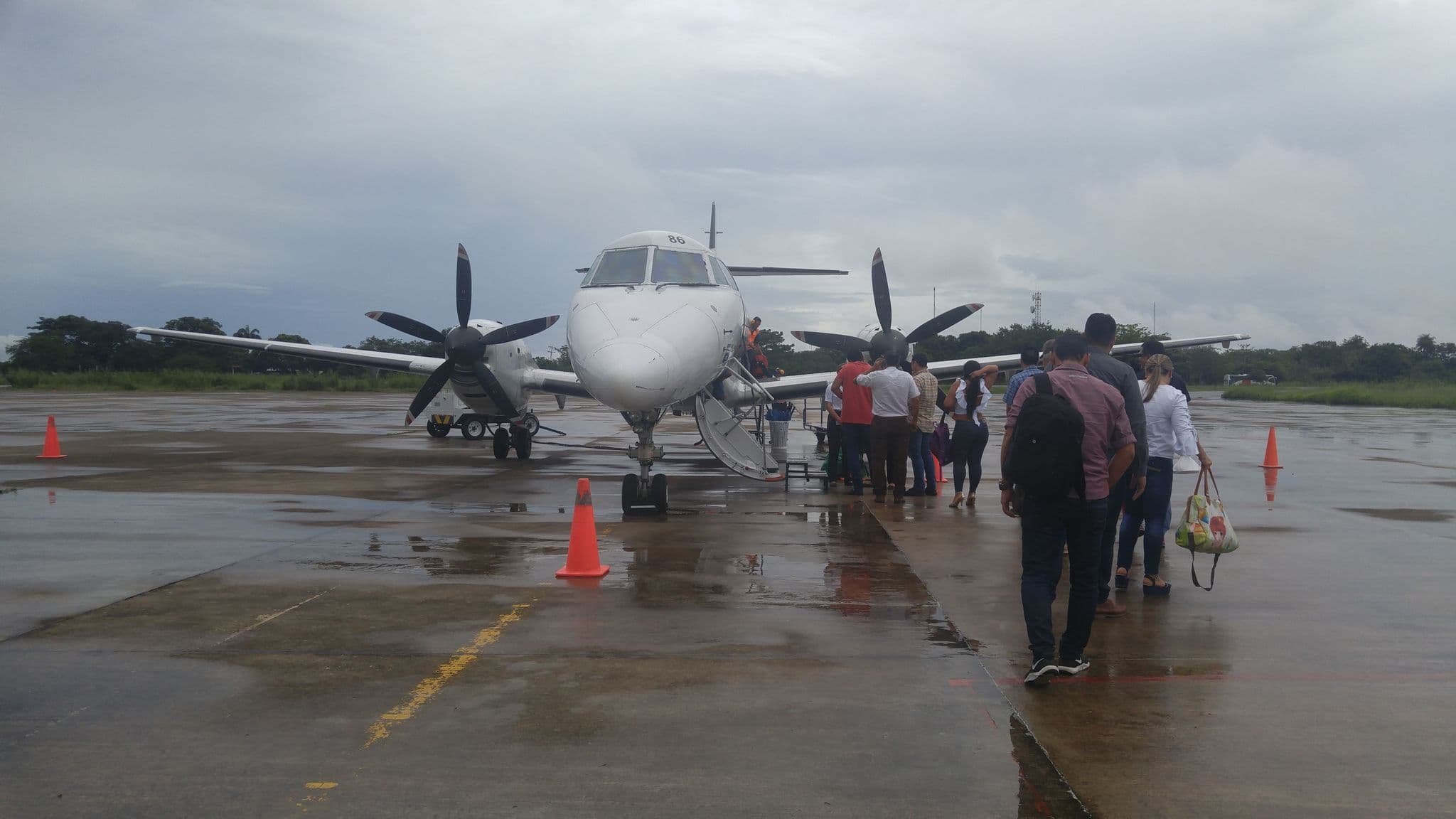 Passengers walking across the apron to board an EasyFly turboprop in Colombia