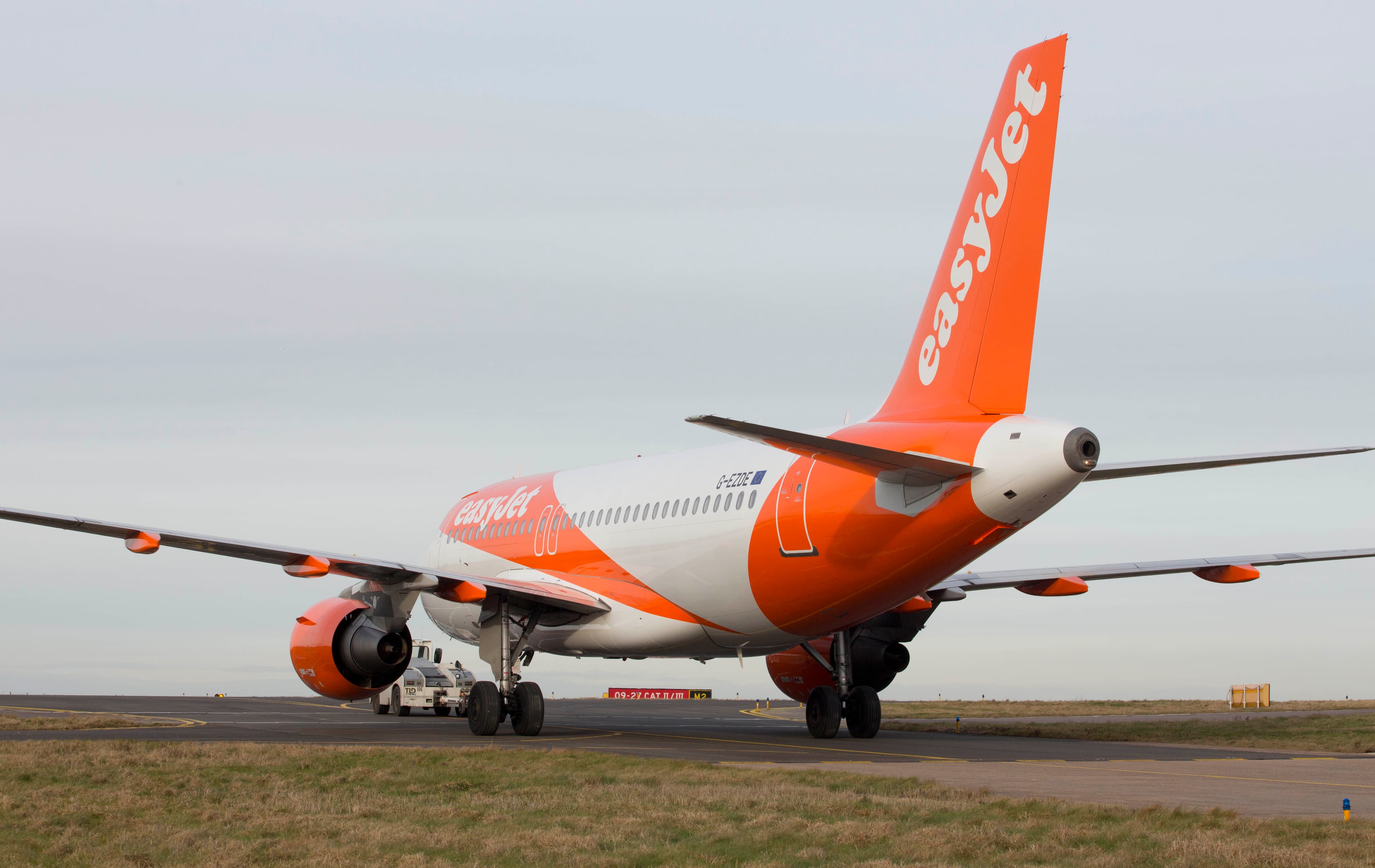 easyJet aircraft with orange tail taxiing on the runway