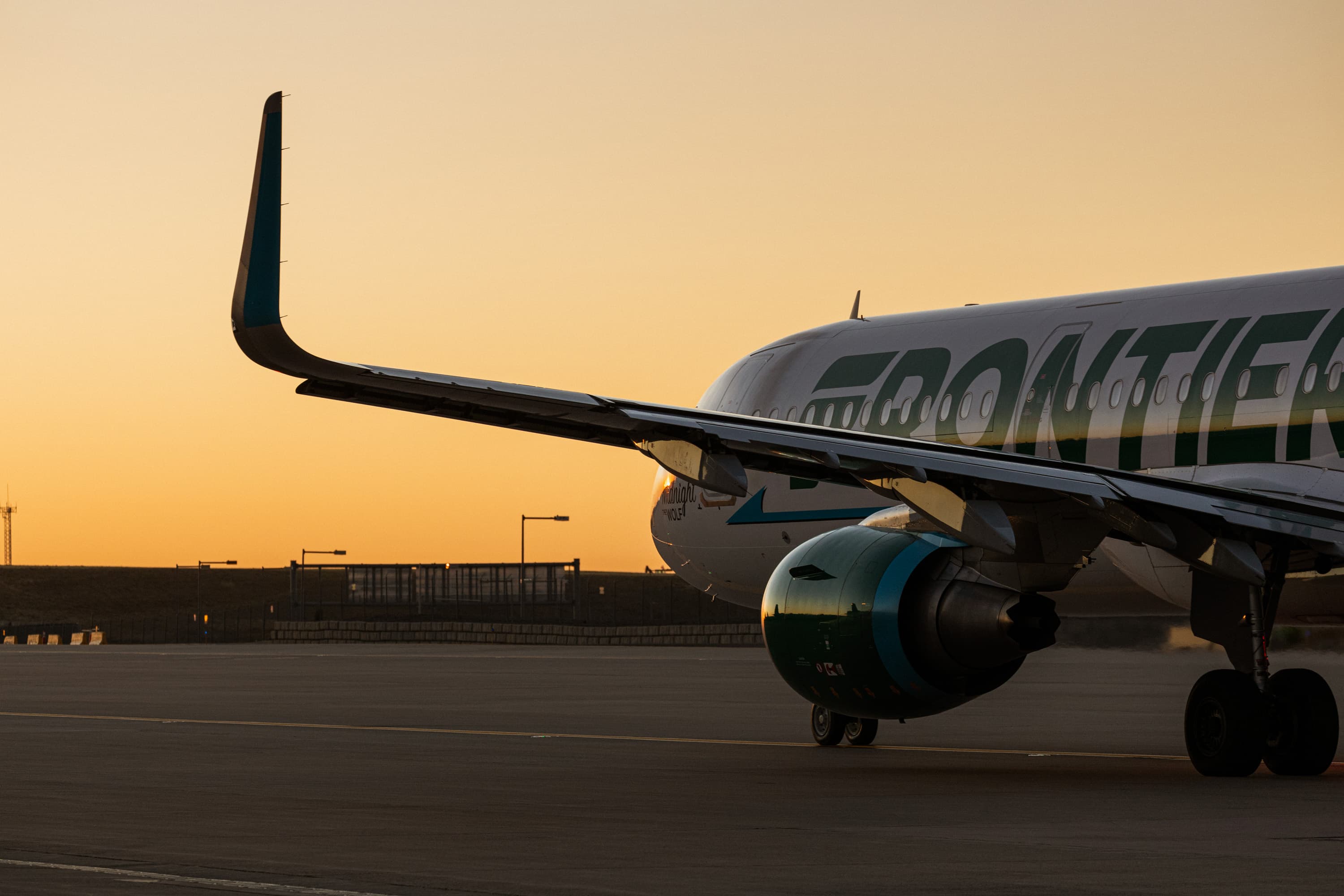 Frontier Airlines aircraft on the tarmac at sunset