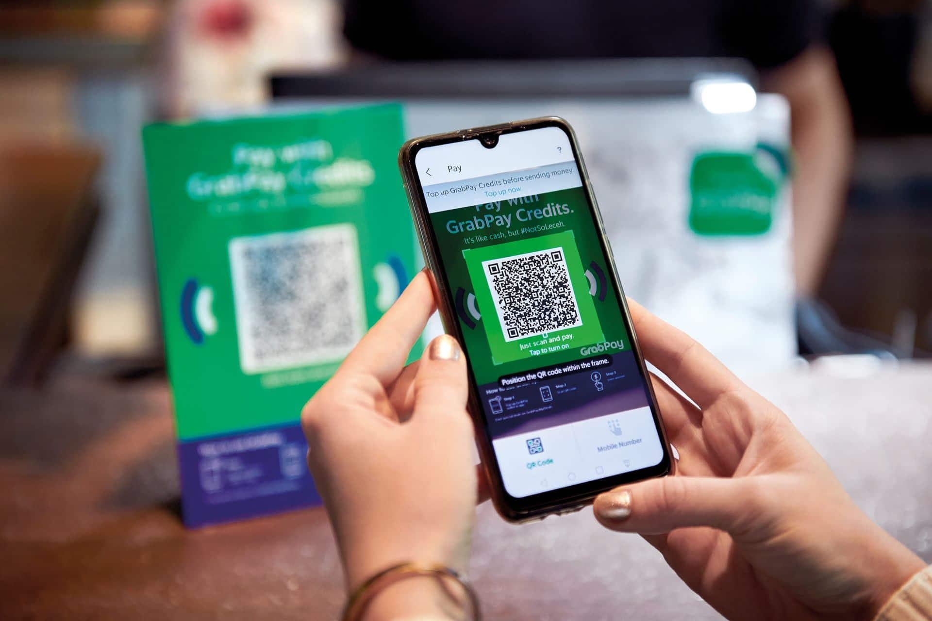 Customer scanning a GrabPay QR code to pay a merchant