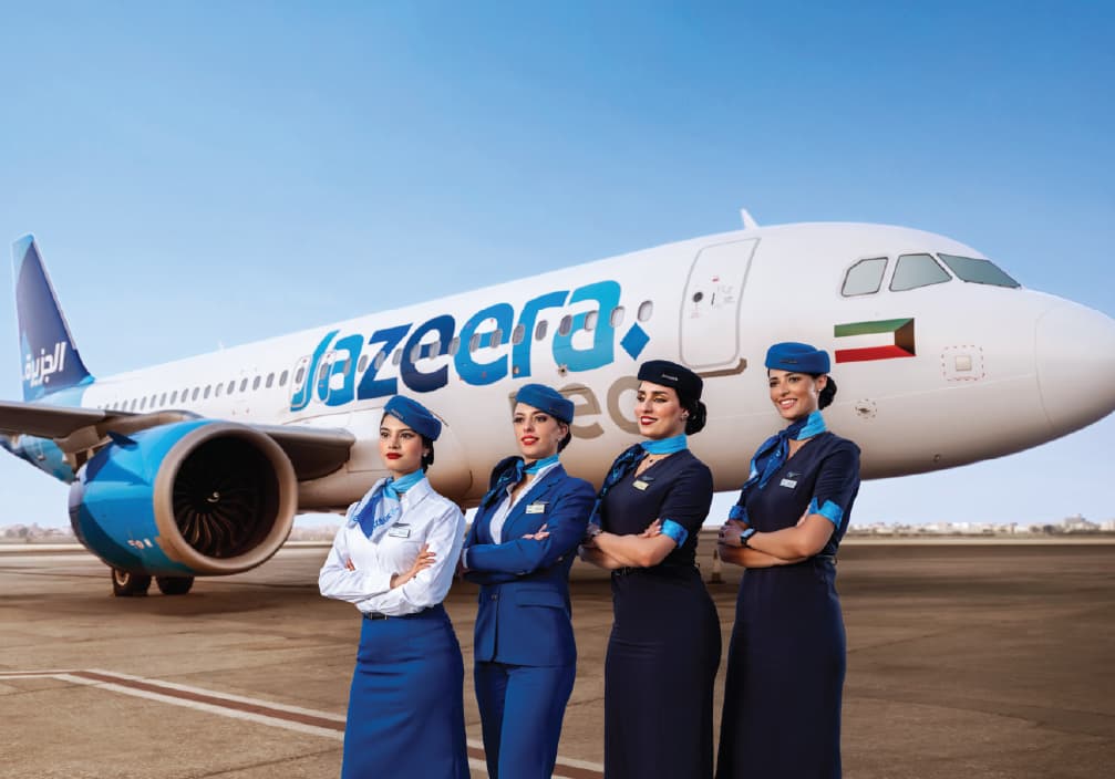 四名 Jazeera Airways 客艙組員，站在一架 Jazeera Airways 空中巴士 A320neo 前方的停機坪上