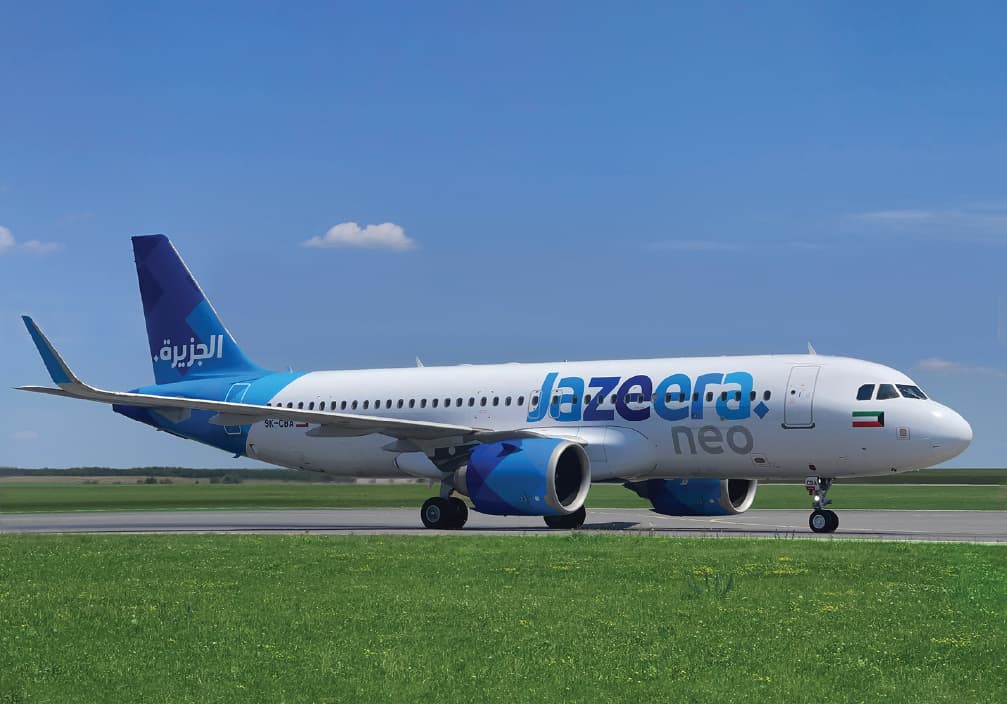 Jazeera Airways 空中巴士 A320neo，藍白色塗裝，在藍天下滑行，經過綠草地