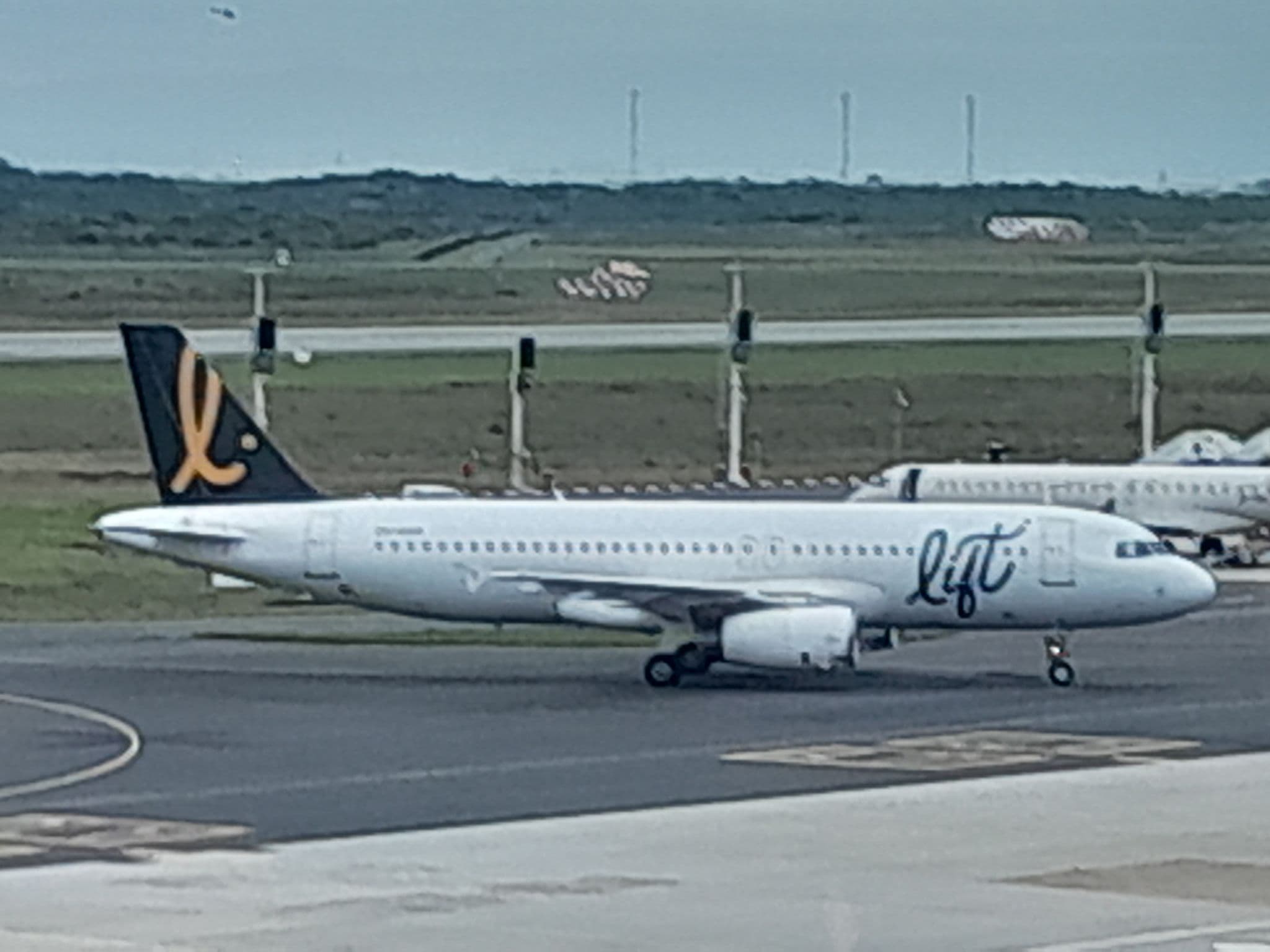 Side view of LIFT Airbus A320 ZS-GAO taxiing, showing the LIFT logo and gold tail