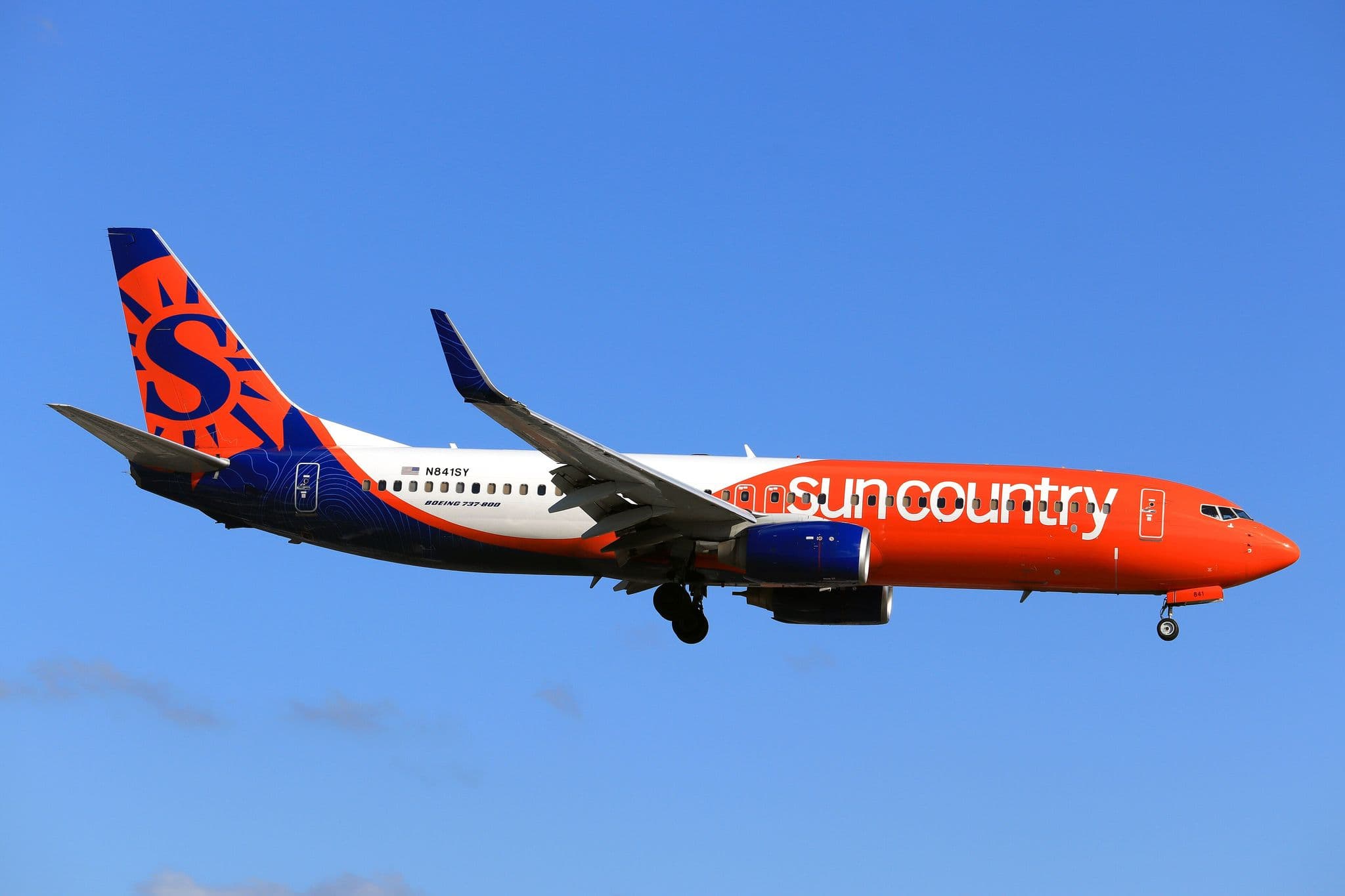 Sun Country Boeing 737-800 on approach against a blue sky