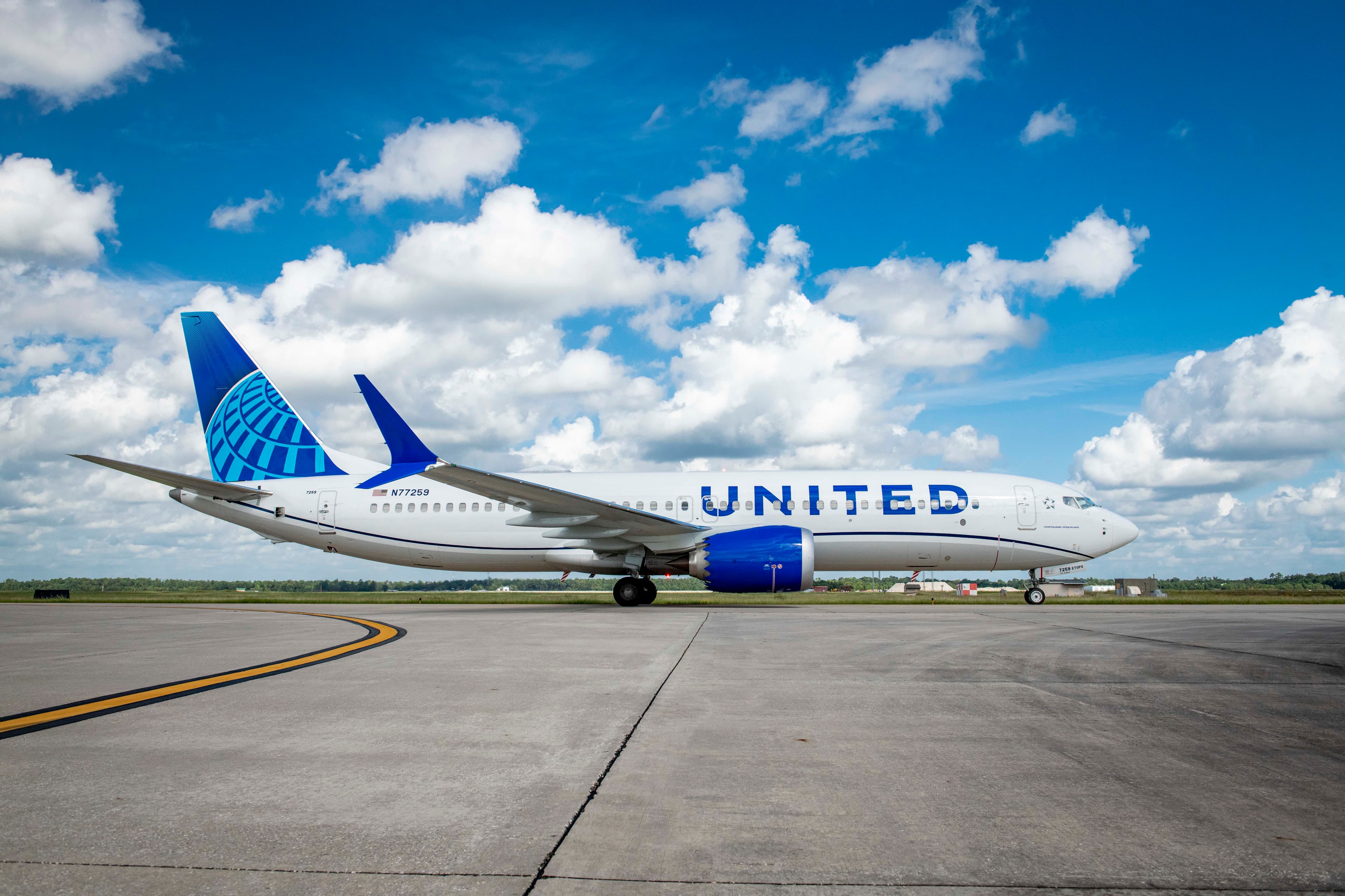 United Airlines Boeing 737 MAX 8 in blue livery parked on the airport apron