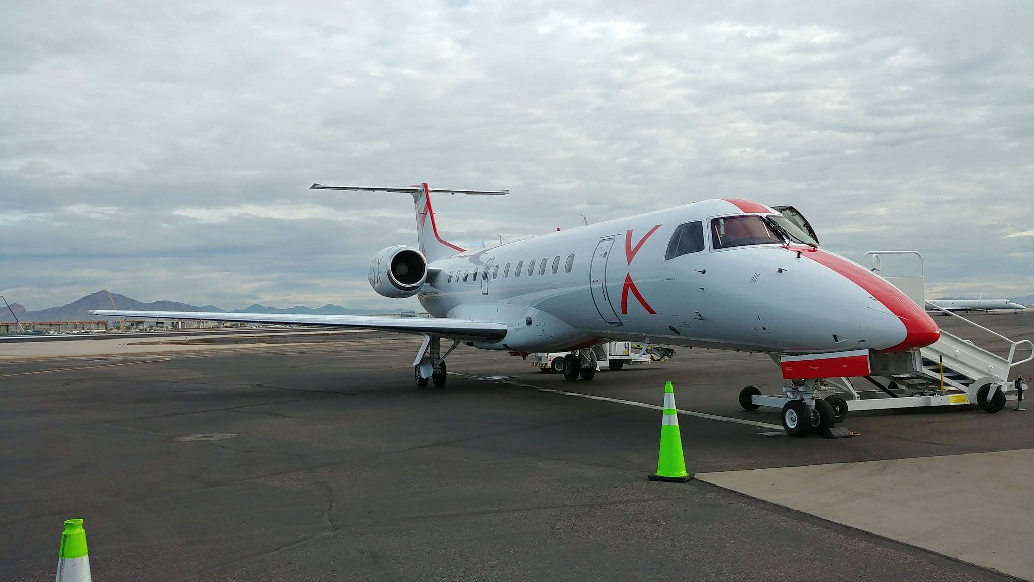 JSX Embraer jet boarding passengers on the ramp at Phoenix Sky Harbor Airport