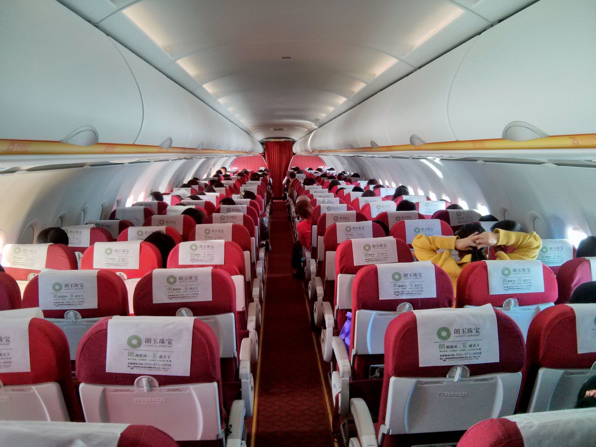 Lucky Air Airbus A320 economy class cabin with red and white seats