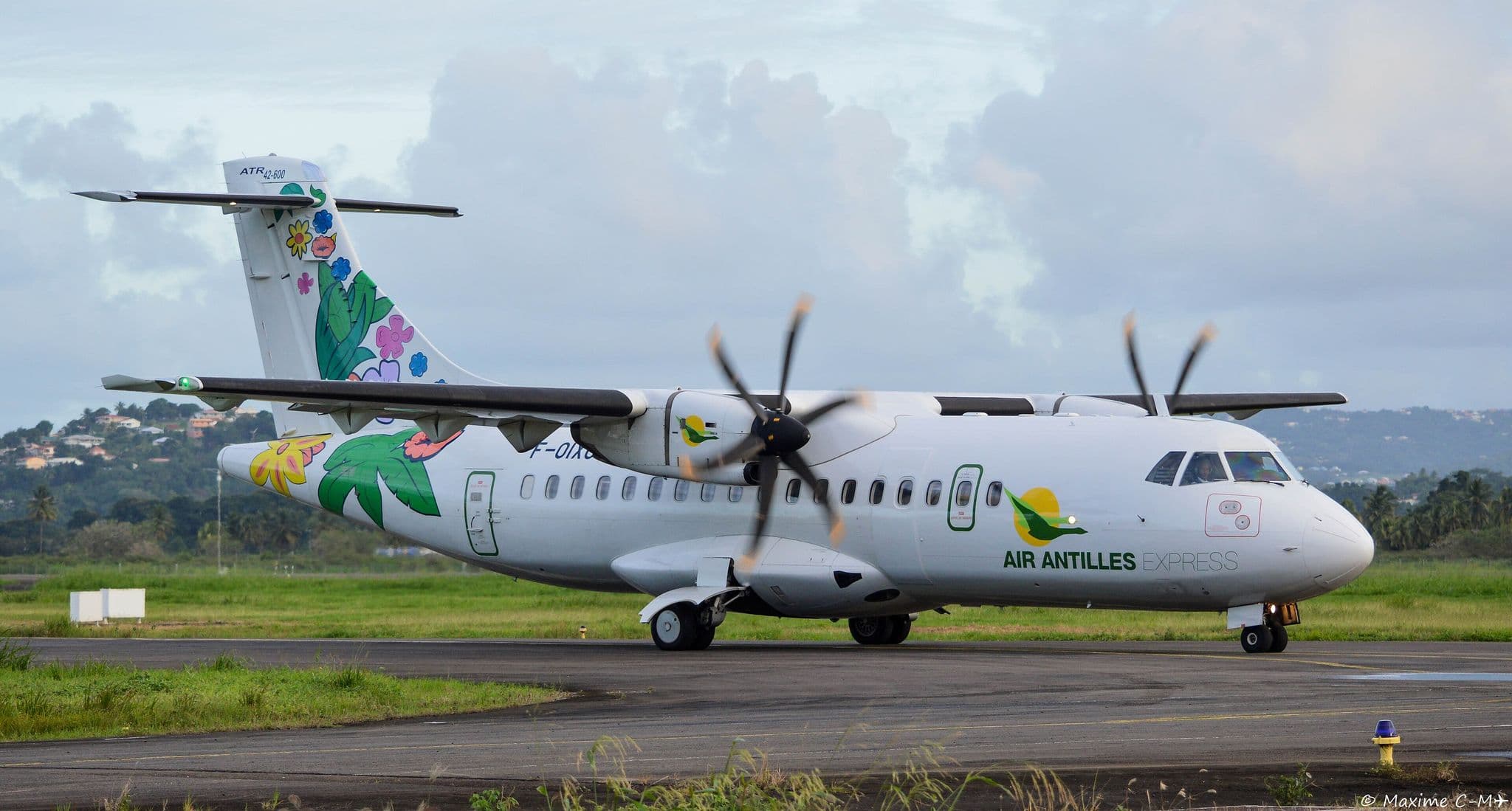 Air Antilles ATR 42-500 in its tropical-flower livery taxiing on a Caribbean runway