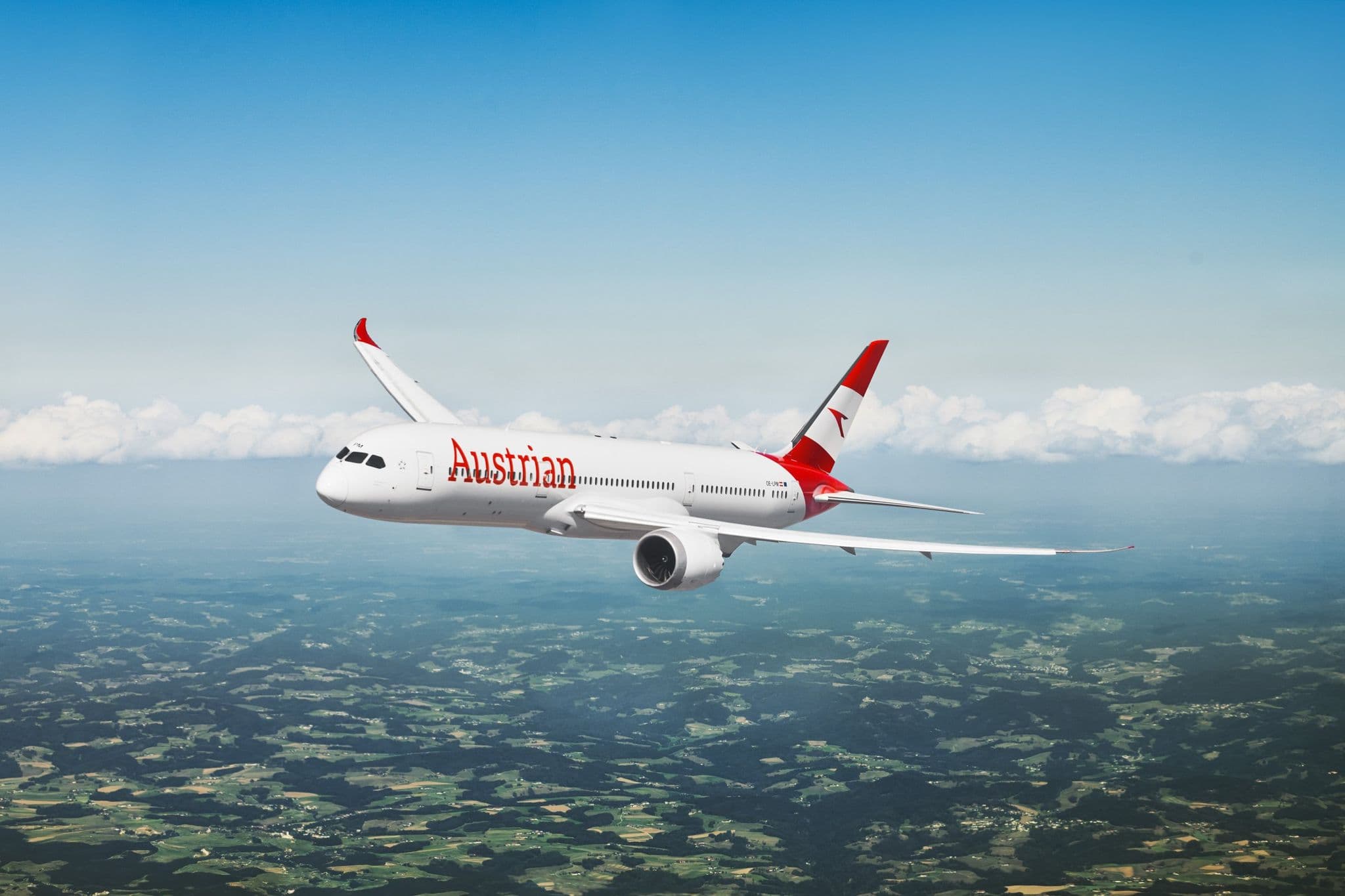 Austrian Airlines Boeing 787-9 Dreamliner 客機飛行於農田與雲層上空
