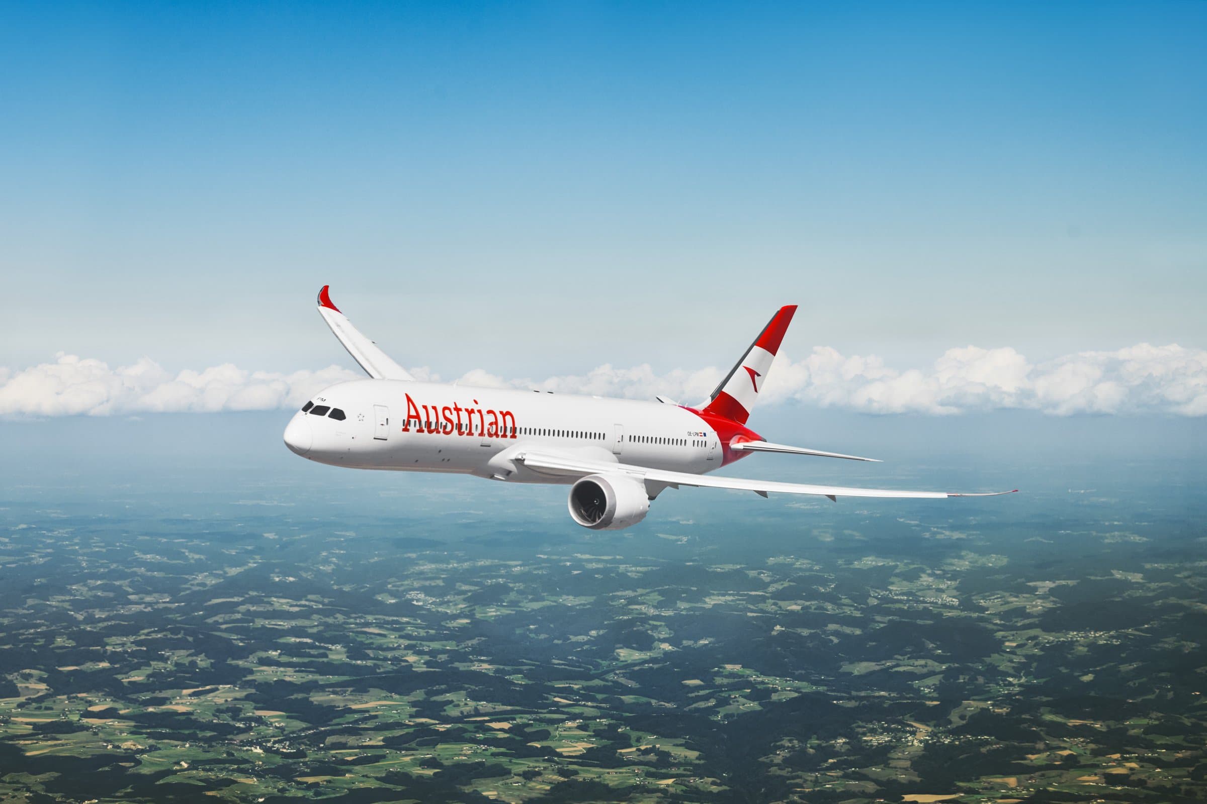 농경지와 구름 위를 비행 중인 Austrian Airlines Boeing 787-9 Dreamliner