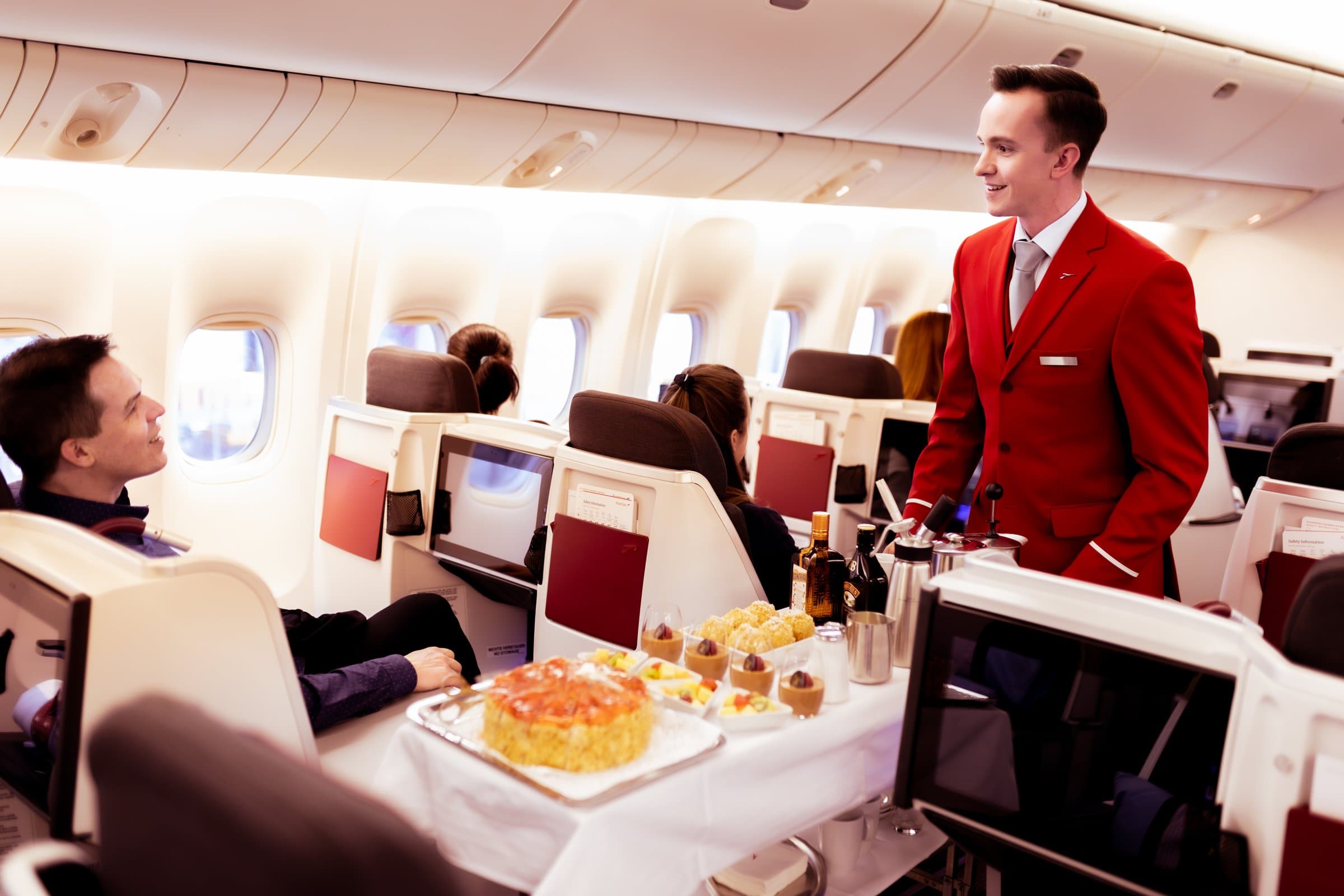 장거리 노선 비즈니스 클래스 객실에서 승객에게 서비스하는 Austrian Airlines 승무원