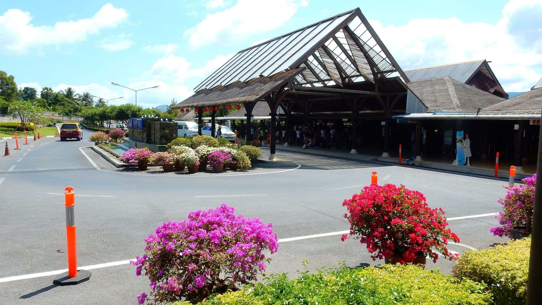 Open-air terminal pavilions and flower beds at Samui Airport, operated by Bangkok Airways