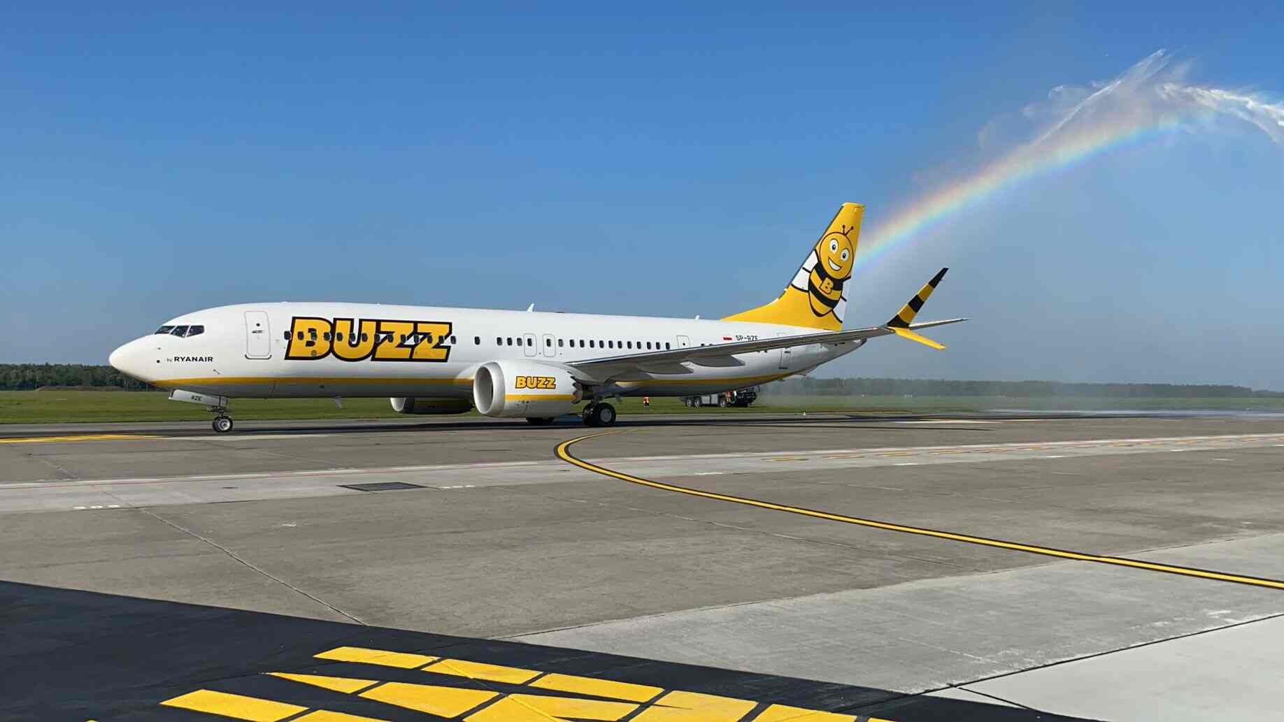 Buzz Boeing 737 on the apron with a rainbow over the tail