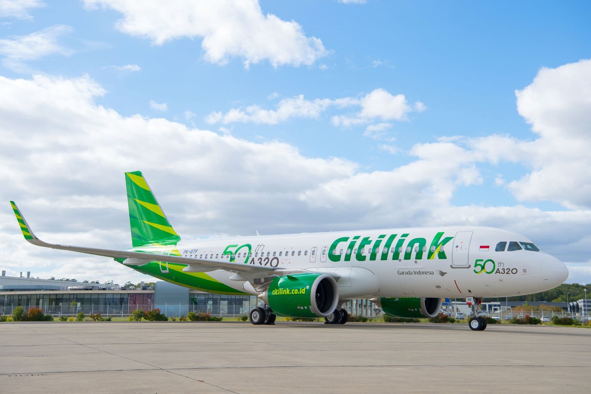 Citilink空客A320neo飞机停放在停机坪上,头顶是蓝天白云