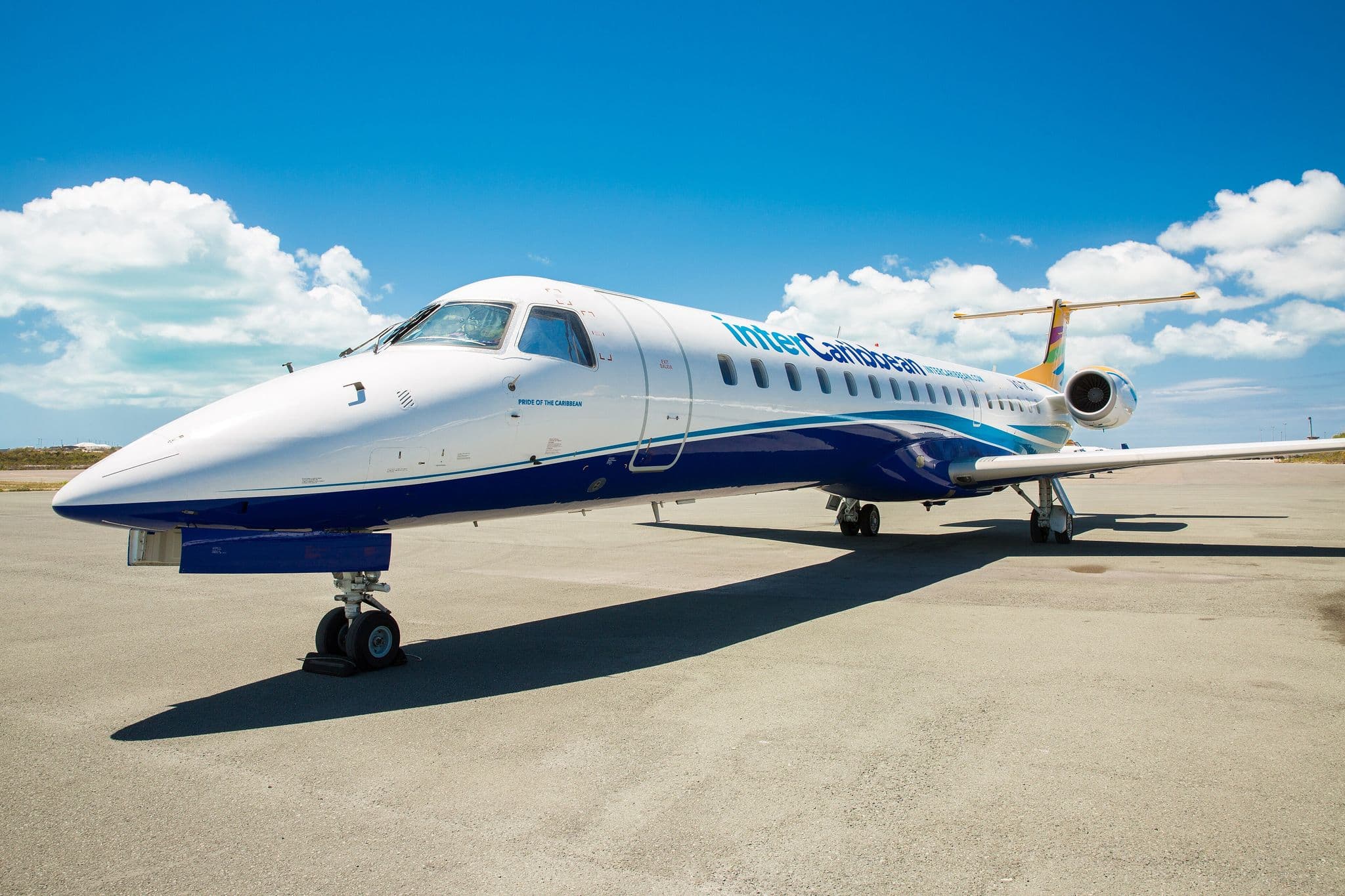InterCaribbean Airways Embraer ERJ-145 jet parked on the apron under a blue sky