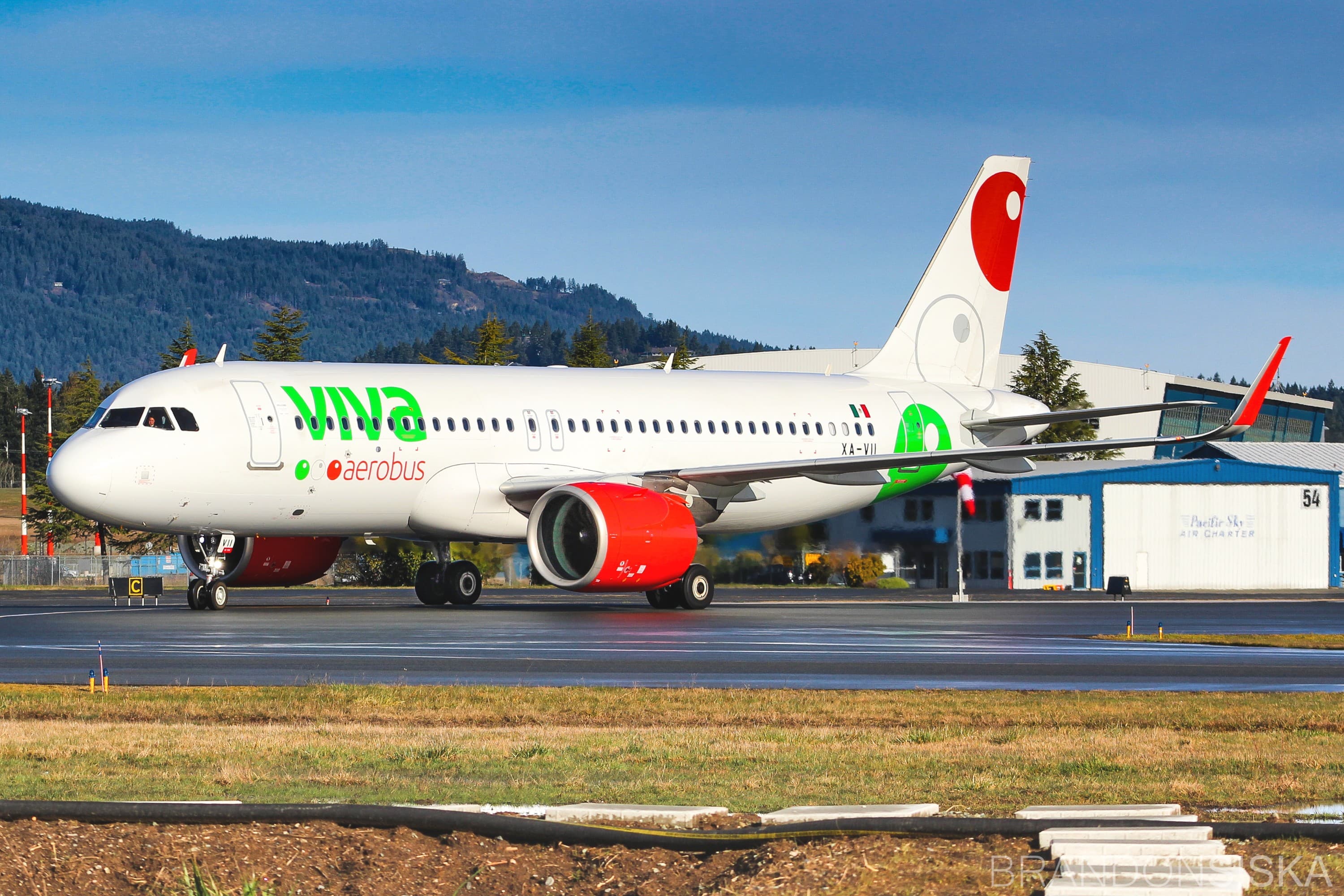Viva Aerobus 空客 A320neo 客机 XA-VII 在滑行道上滑行,背景是群山